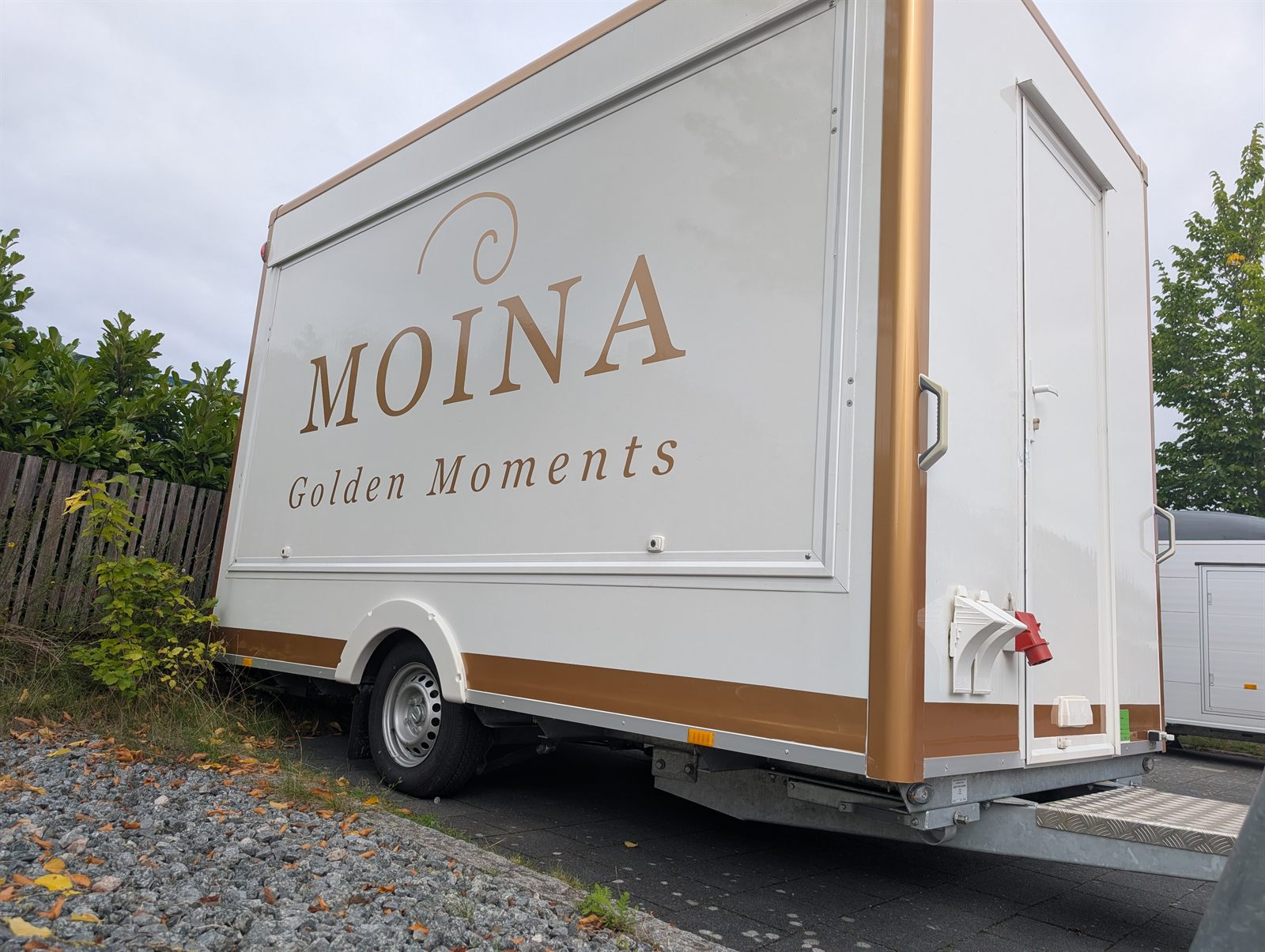 Der MOINA-Verkaufsanhänger in der Schrägansicht mit Verkaufsklappe und Seitentür