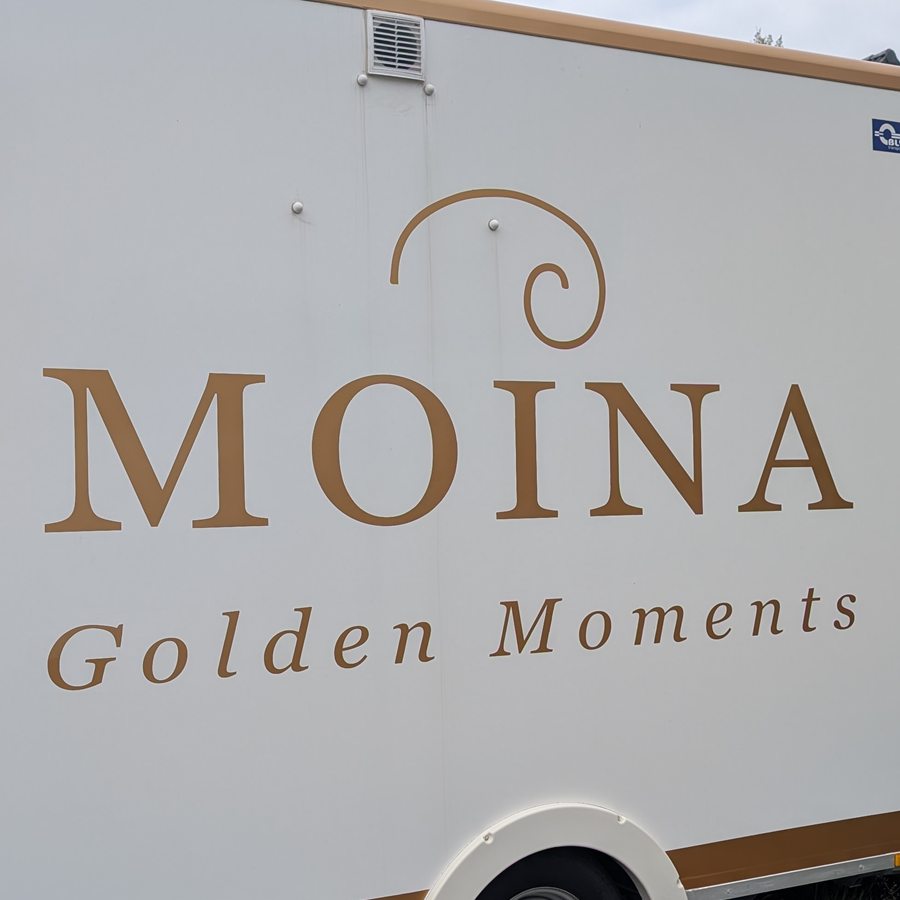 Der goldene MOINA-Schriftzug auf dem Anhänger aus der Nähe